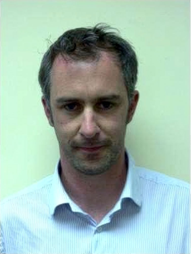 Man in a striped shirt, neutral expression.