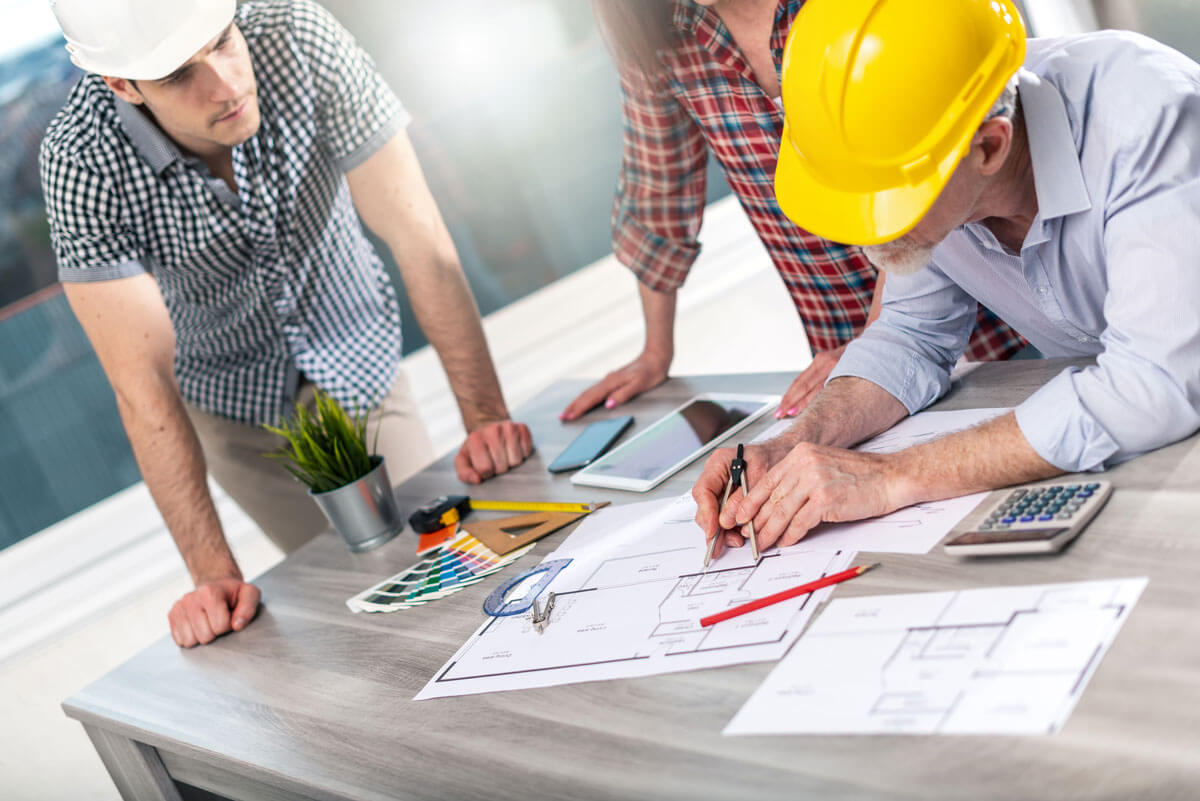 Architects discussing blueprints at a table.