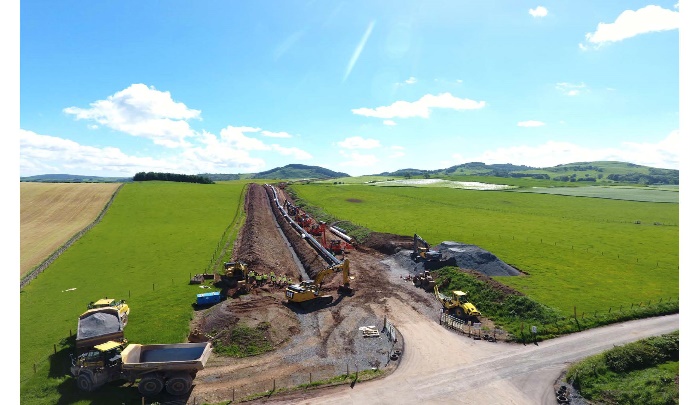 Construction site with machinery in open countryside.