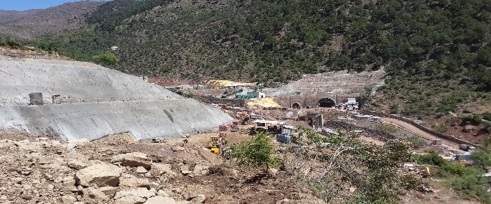 Mountain construction site with tunnels and equipment.