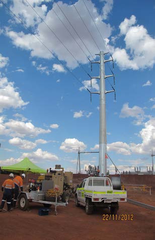 Workers installing power lines in desert landscape.